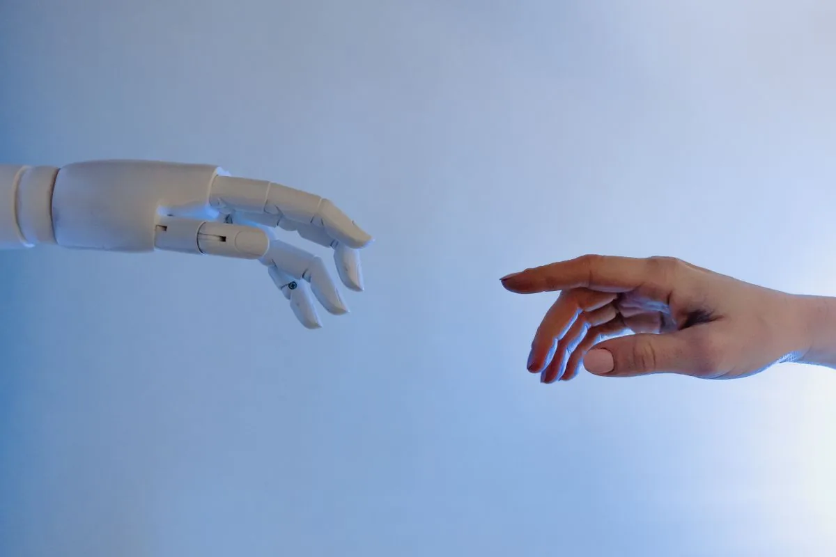 Una mano robótica y una mano humana acercándose entre sí