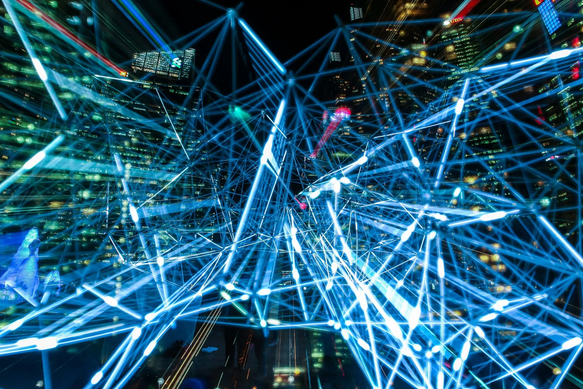 Red de conexiones luminosas trazadas sobre los edificios de una ciudad de noche